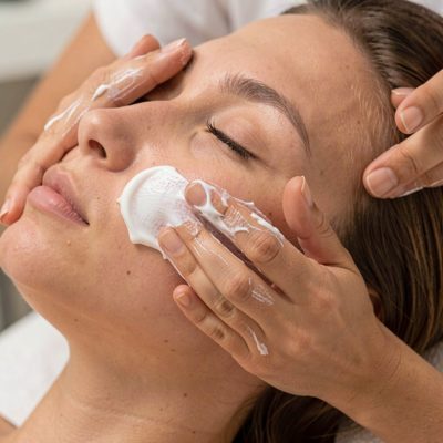 cream being massaged into a client's cheek