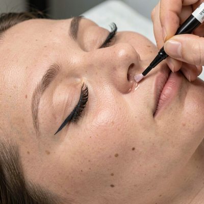 a lash tint being applied to closed eyes