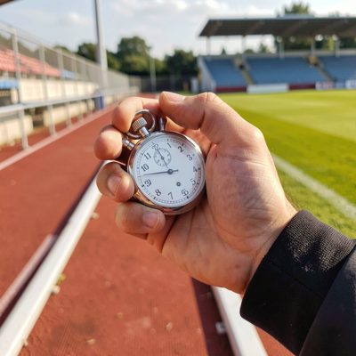 a stopwatch in a coach's hand at trackside