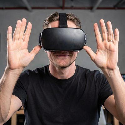 a person wearing a vr headset with hands raised