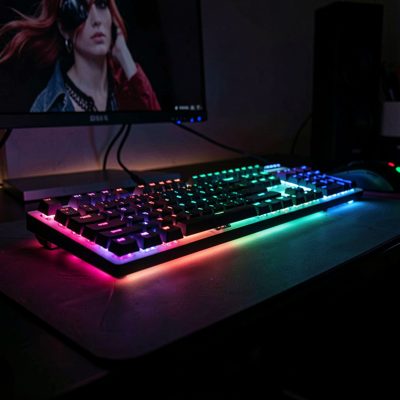 a keyboard and mouse lit by coloured lighting in a dark room