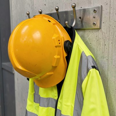 a hard hat and hi vis jacket hanging on a hook