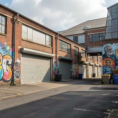 a warehouse district with roller shutters and murals