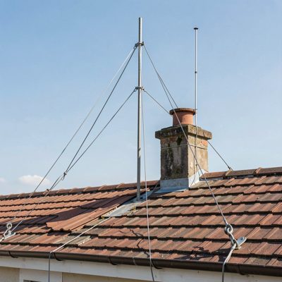 guy wires from a rooftop mast anchored to the roof