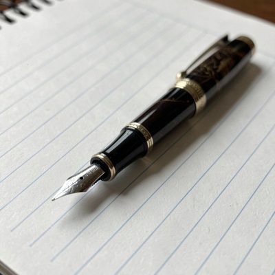 a fountain pen resting on lined paper