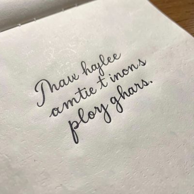 a hand writing in cursive on paper