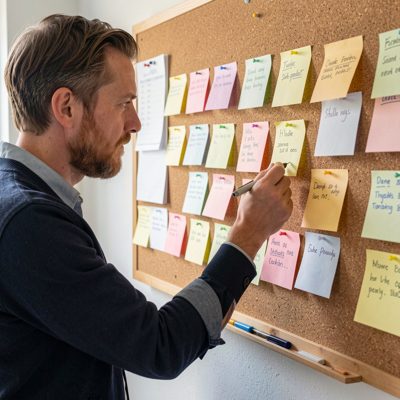 a writer pinning notes to a corkboard