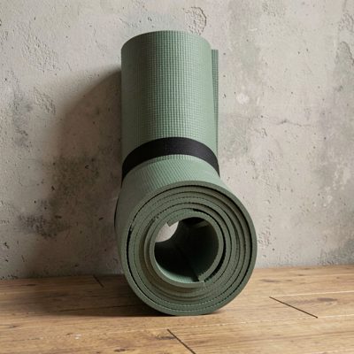 a rolled yoga mat against a studio wall