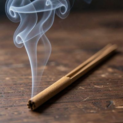 an incense stick with a thread of smoke