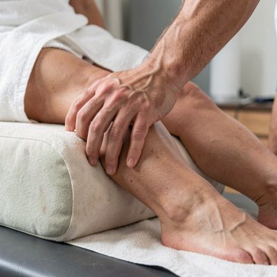 a hand adjusting a bolster under knees